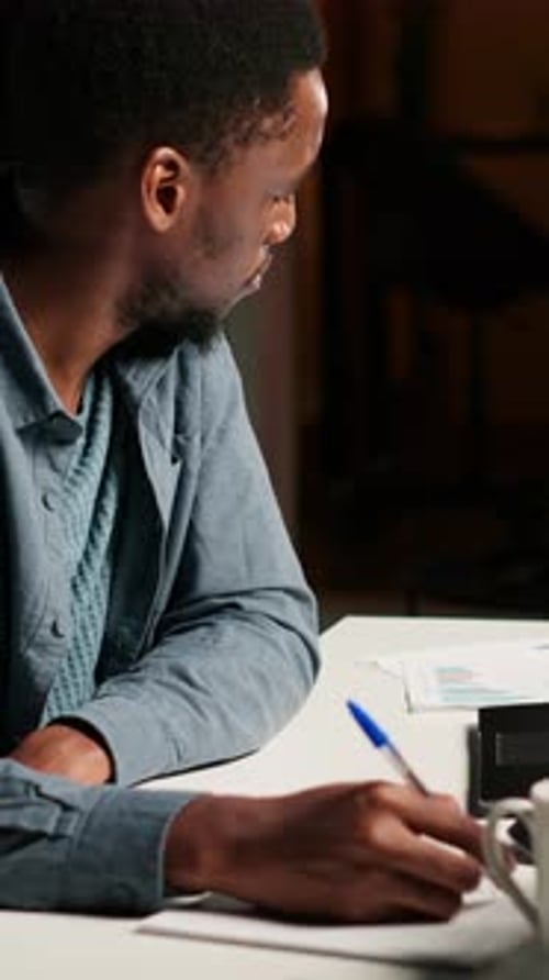 Vertical Video African American Freelancer Working From Home Writing Notes and Researching