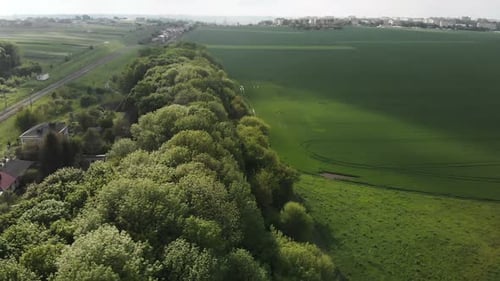 Luftaufnahme der Drohne von grünem Grasfeld und dunklem Himmel mit Wolken vor Regen