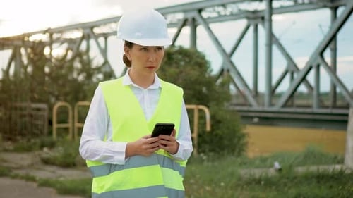 Portrait Professional Engineer Woman Manager Wearing Helmet Using Mobile Smart Phone Application on