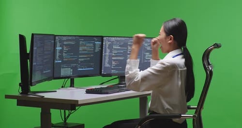 Woman Developer Celebrating And Dancing While Write Code With Multiple Screens In Green Screen