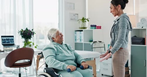 Senior Woman Exercising with Trainer in Rehab Center