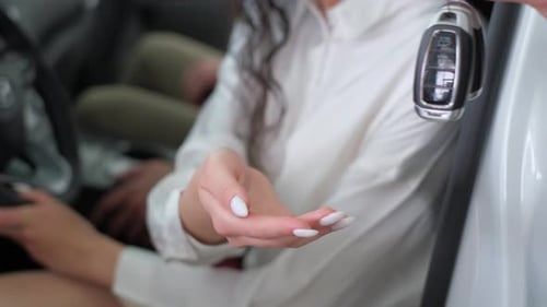 Closeup of a Cardier's Hand Giving a New Car Key to a Woman The Seller Giving the Keys to the Client