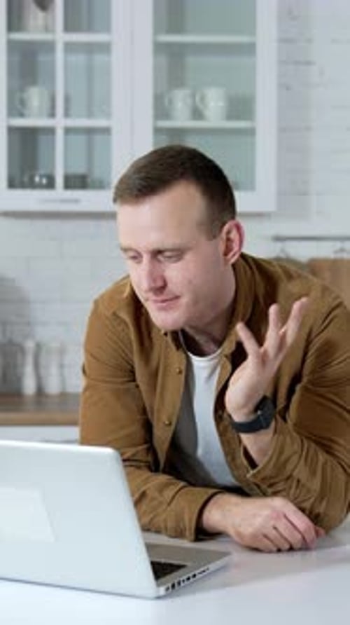 Man Talking on Laptop in Home Office