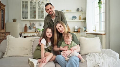 Loving Family Poses Together on Sofa at Home