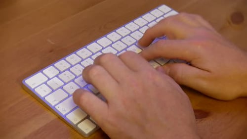 Finger tippen auf Computertastatur auf Holztisch