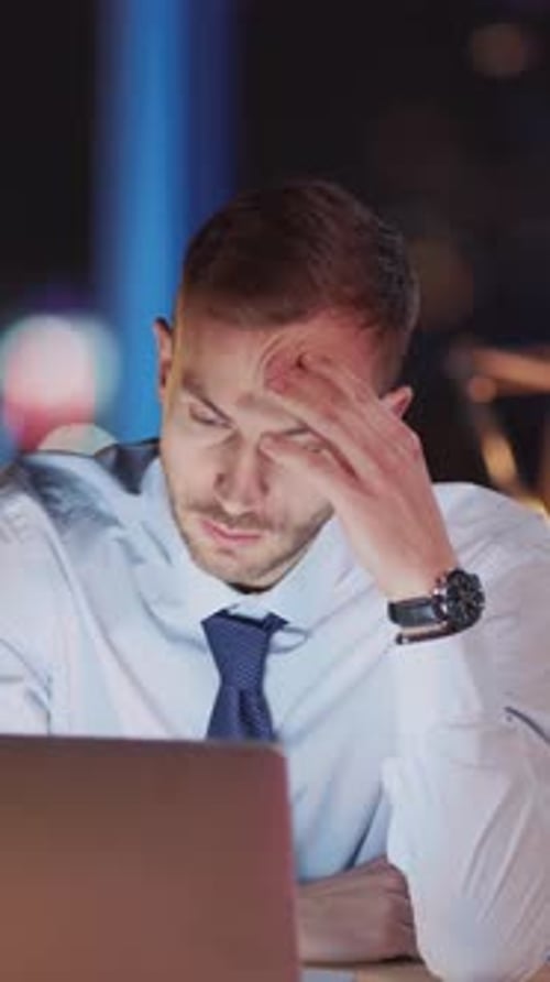 Stressed Man Working Late at Office Desk