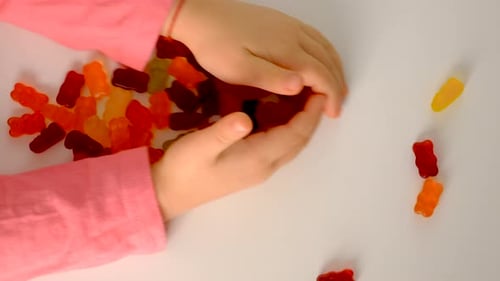 Child Gathering Colorful Gummy Bear Candies