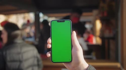 Young Man Holding Phone Chroma Key Screen on the Street in Front of Food Market Closeup Male with