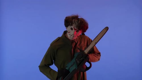 Man in White Mask with Chainsaw in Hands on Blue Background with Red Neon Light Image of Jason