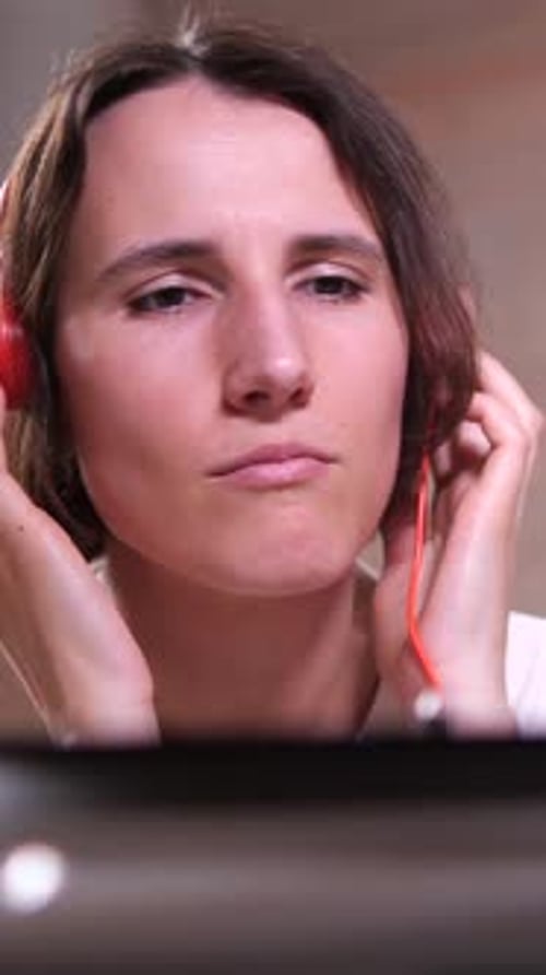 Vertical Video Music Lover Girl in Orange Headphones Listens to Music