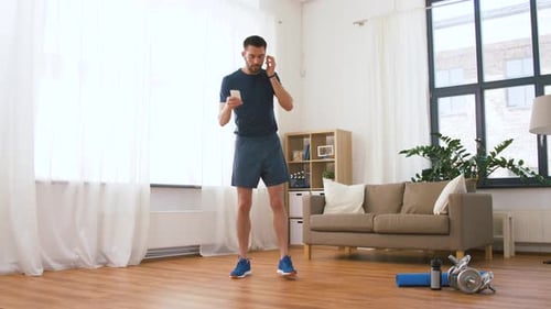 Man in Athletic Wear Using Phone Then Exercising
