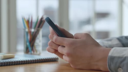 Hands Man benutzt Smartphone im Wohnzimmer zu Hause, Seitenansicht
