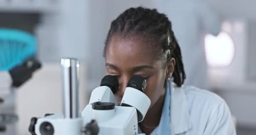 Woman Researcher Using Microscope in Bright Laboratory