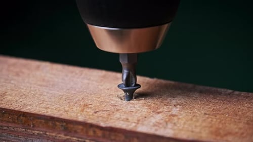 CloseUp of Unscrewing the Screw From a Block of Wood With a Screwdriver