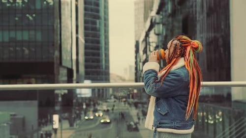 Stylish Young Adult Sipping Coffee in Urban Setting