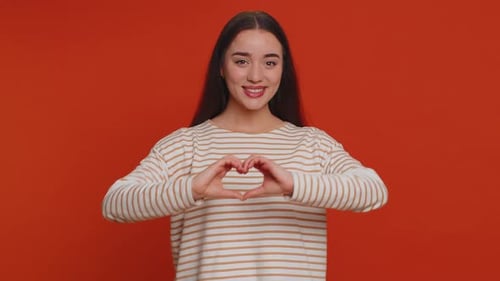 Smiling Woman Makes Heart Shape With Hands