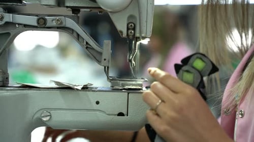 Young Blond Woman Working on Sewing Machine in Factory