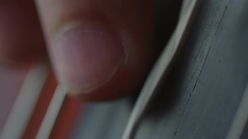 Close Up of Fingers Plucking Guitar Strings