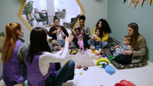 Kindergarten teachers leading a playgroup with mothers and toddlers