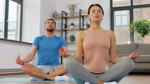 Couple Meditating at Home on Yoga Mats