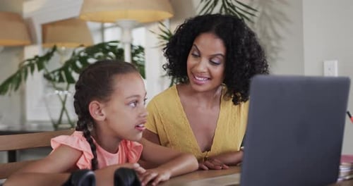 Mother and Daughter Chatting Together on Laptop