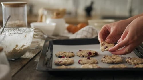 Hands Placing Homemade Cookie Dough on Baking Sheet