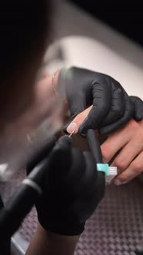 Manicurist filing fingernails close up in salon