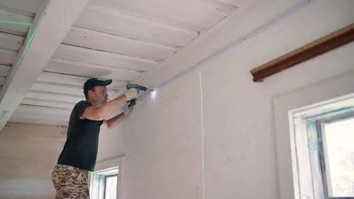 An Electrician Works with a Drill to Create Electrical Wiring