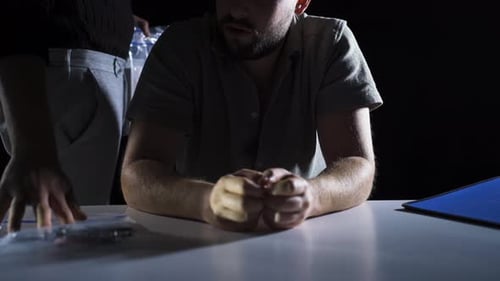 Man Interrogated with Evidence Presented on Table