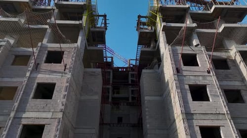Vídeo aéreo Los trabajadores de la construcción manipulan metales y ladrillos que refuerzan la estructura del edificio en un