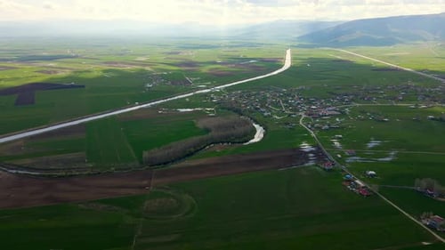 Aerial view of a wide, open plain with roads and streams running through it