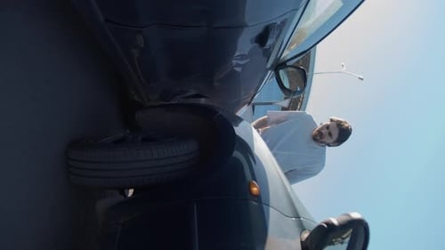Frustrated Man Stands Next to Wrecked Car