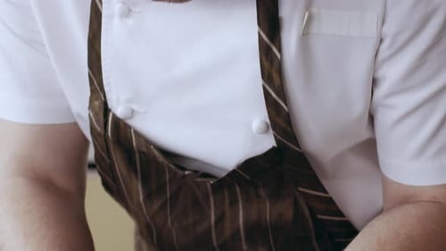 Chef plating thin sliced meat in a kitchen