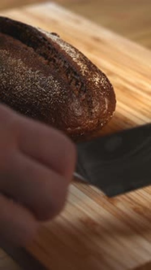 Person Preparing Bread and Knife on Cutting Board Media