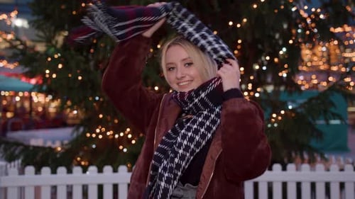 Smiling Woman Posing in Front of Christmas Tree