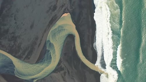 Yellow river mouth on black sand beach in south Iceland Aerial Footage
