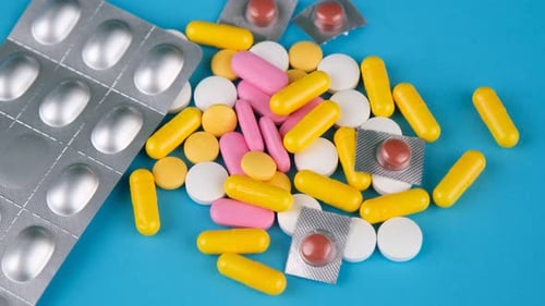 Assorted Pills and Capsules on Blue Background