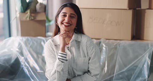Smiling Young Woman in New Home with Moving Boxes