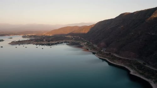 Aerial drone flying over a lake, water dam, with mountains at sunrise. Beautifull dreamy landscape