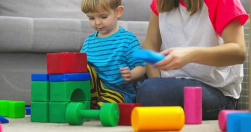 Child and Adult Building Colorful Tower at Home