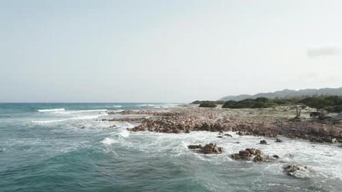Aerial view drone over beach sea and rock coast with powerful sea waves. Beach sand and amazing sea