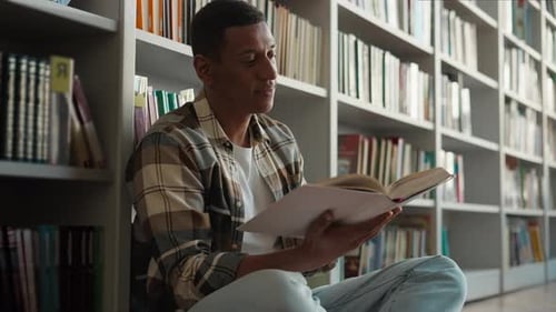 African American Man Sitting Library Floor Bookcase Reading Book Pleasure Hobbies Story Knowledge