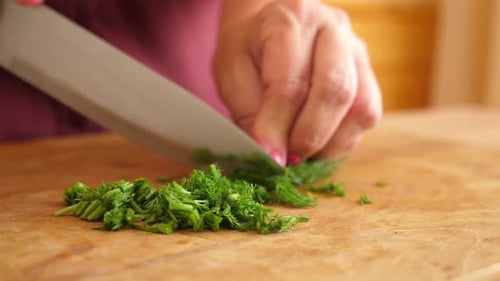 06. Finely chop the dill with a knife on a wooden board.