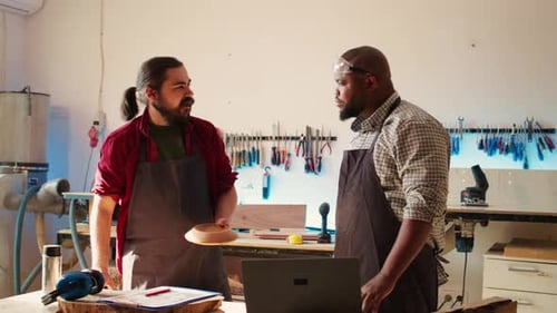 Men Discussing Woodworking Project in Workshop