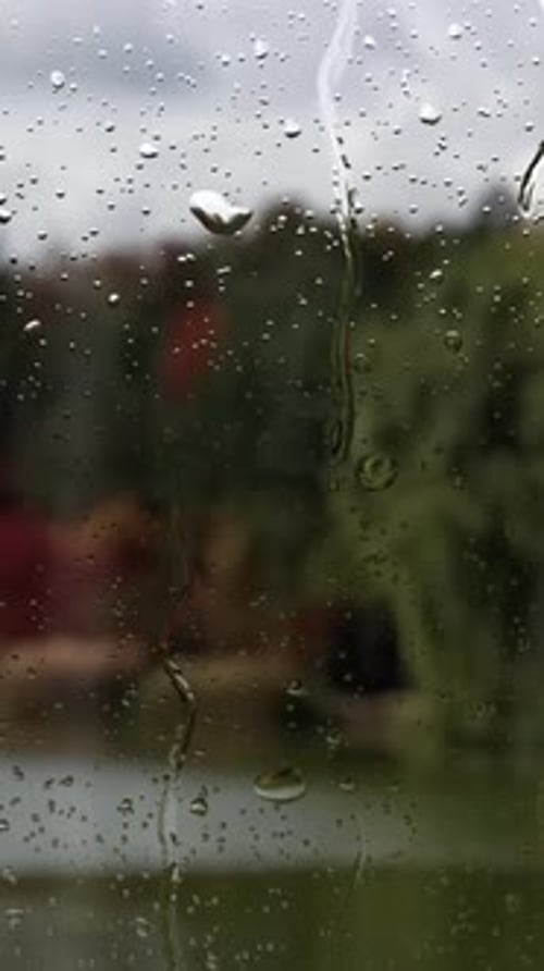 Raindrops Falling Down a Window Pane on a Gloomy Day