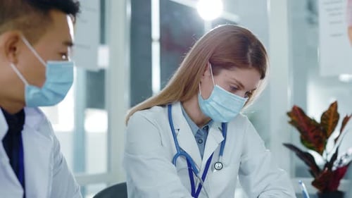 Medical Professionals Collaborate in Hospital Setting Wearing Masks