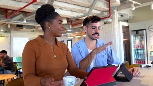 Young Adults Discussing Project with Tablet in Workplace