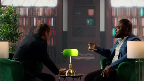Businessmen in a Classy Library Discuss Partnership Goals Over Whiskey