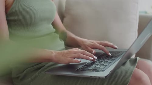 Woman Working on Laptop at Home on Couch