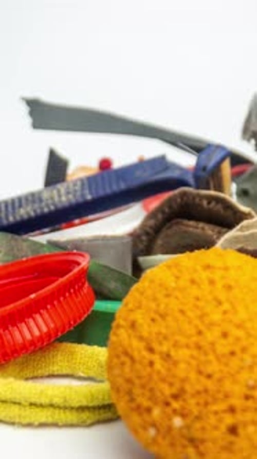 Plastic Rubbish and Waste Items Building Up on White Background in Vertical Format